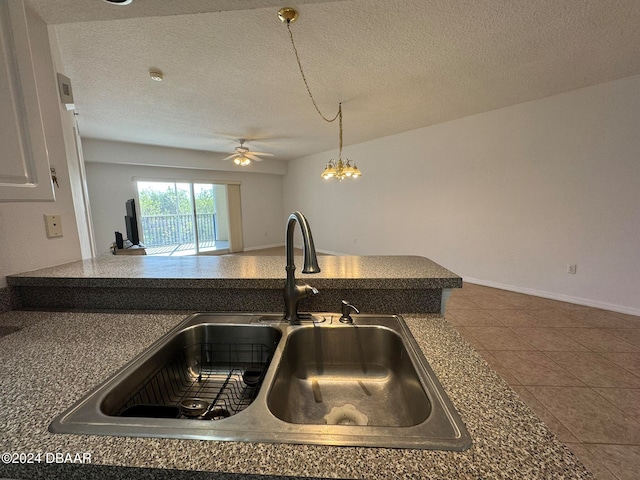 kitchen with ceiling fan, tile patterned floors, sink, and a textured ceiling