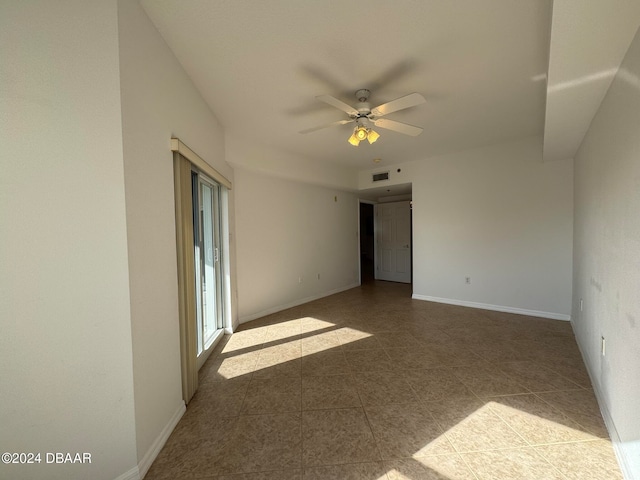 tiled empty room featuring ceiling fan