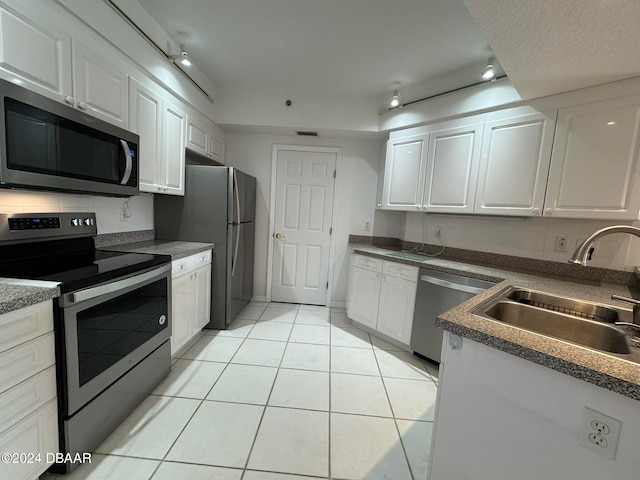 kitchen featuring sink, decorative backsplash, stainless steel appliances, and white cabinets