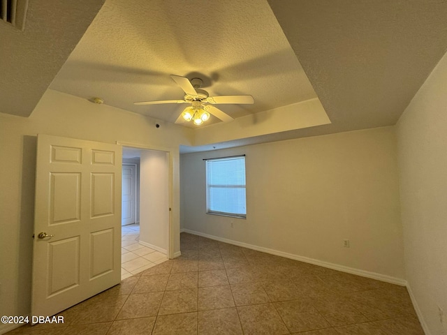 tiled spare room featuring a textured ceiling and ceiling fan