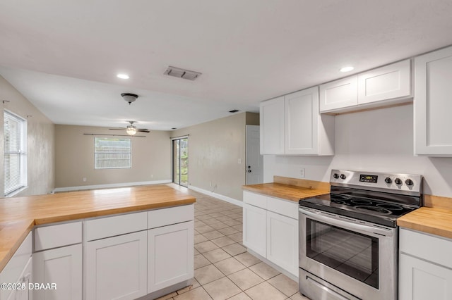 kitchen featuring ceiling fan, wood counters, stainless steel electric range oven, and white cabinets