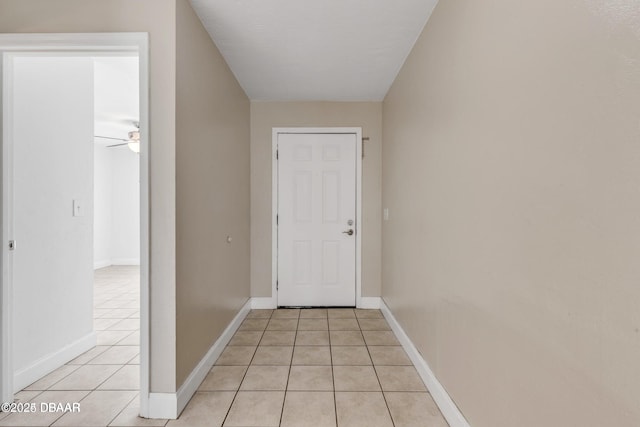 doorway with light tile patterned floors and ceiling fan