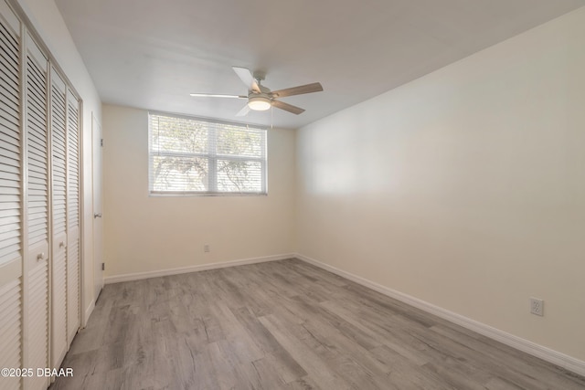 unfurnished bedroom with baseboards, light wood-type flooring, a closet, and ceiling fan