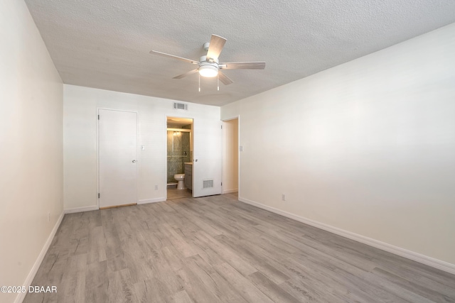 unfurnished bedroom with baseboards, visible vents, light wood finished floors, and a textured ceiling