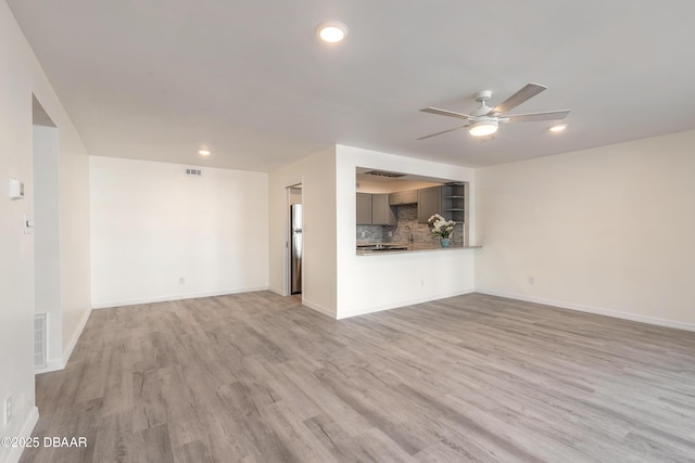 unfurnished living room with baseboards, a ceiling fan, and wood finished floors