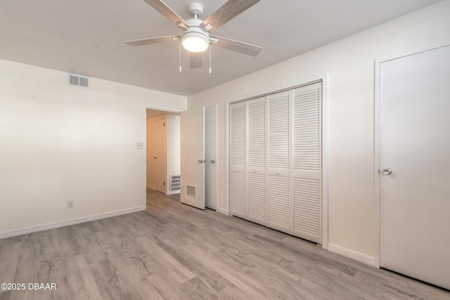 unfurnished bedroom featuring a ceiling fan, light wood-style flooring, baseboards, and visible vents