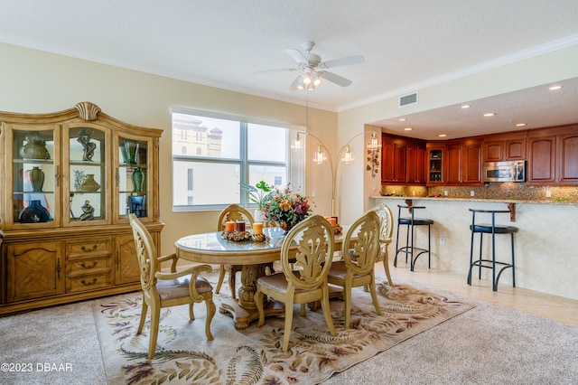 3801 S Atlantic Ave Unit 303, Daytona Beach Shores, FL 32118 - dining area featuring ceiling fan, crown molding, and light carpet