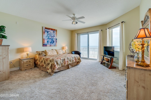 3801 S Atlantic Ave Unit 303, Daytona Beach Shores, FL 32118 - carpeted bedroom featuring access to exterior, baseboards, ceiling fan, and a textured ceiling