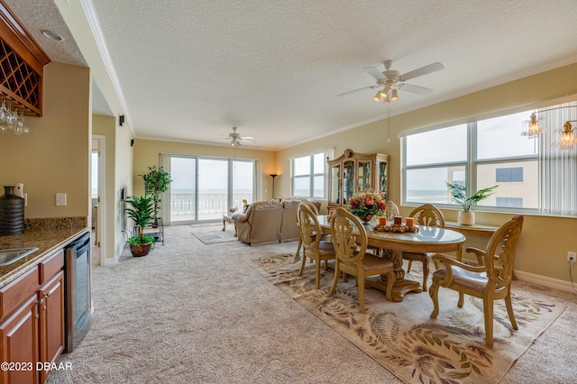 3801 S Atlantic Ave Unit 303, Daytona Beach Shores, FL 32118 - dining space with a textured ceiling, ceiling fan, light colored carpet, and crown molding