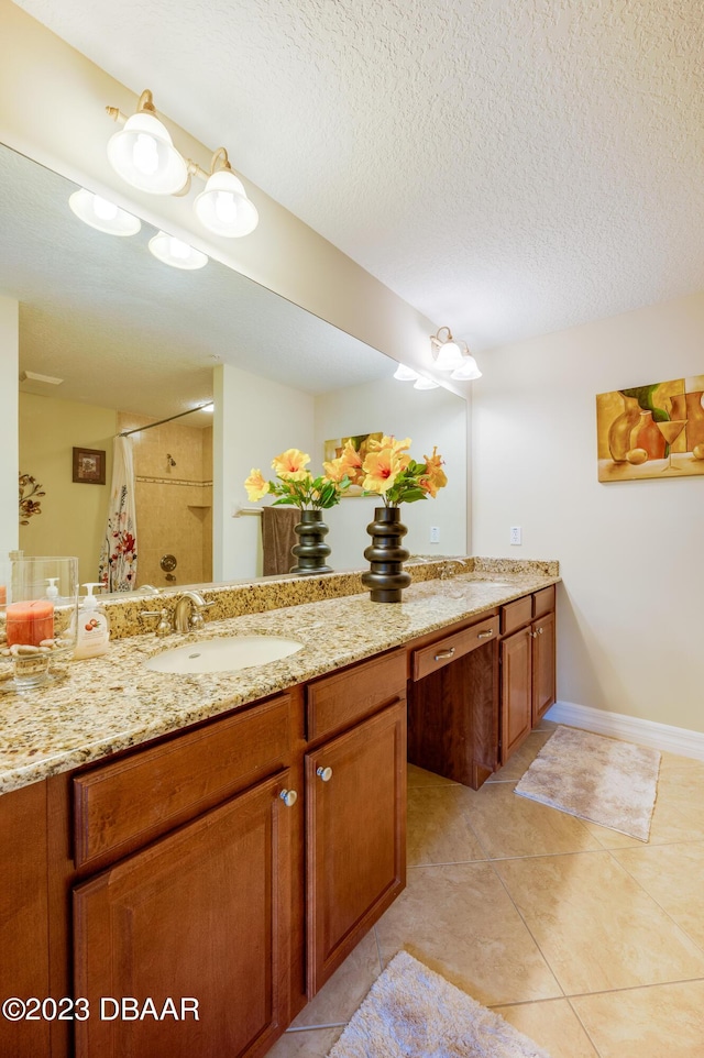 3801 S Atlantic Ave Unit 303, Daytona Beach Shores, FL 32118 - full bath with tile patterned floors, a shower with shower curtain, double vanity, baseboards, and a textured ceiling