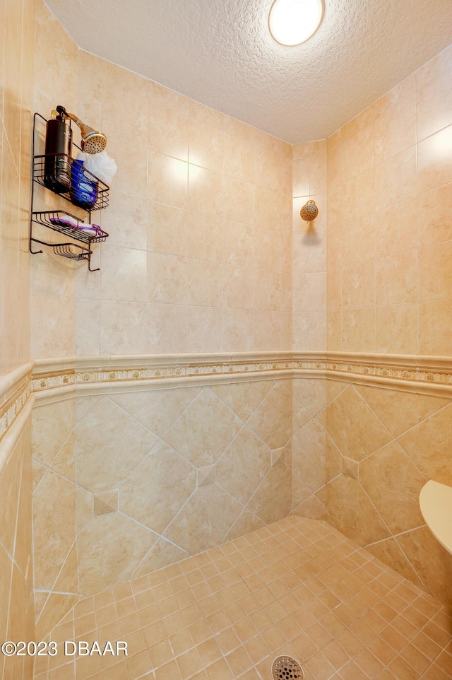 3801 S Atlantic Ave Unit 303, Daytona Beach Shores, FL 32118 - bathroom with a tile shower and a textured ceiling