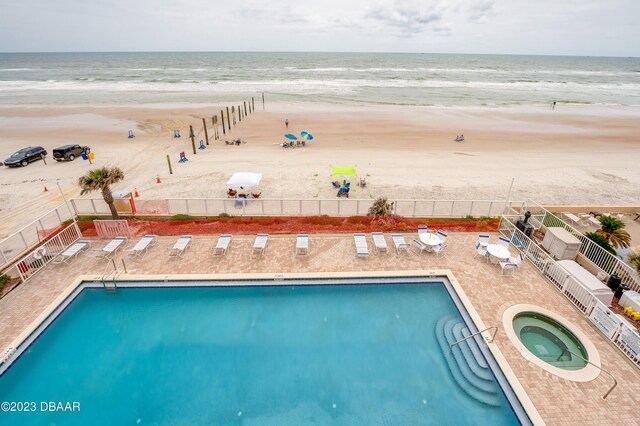 3801 S Atlantic Ave Unit 303, Daytona Beach Shores, FL 32118 - community pool with view of water and beach, fence, and a hot tub