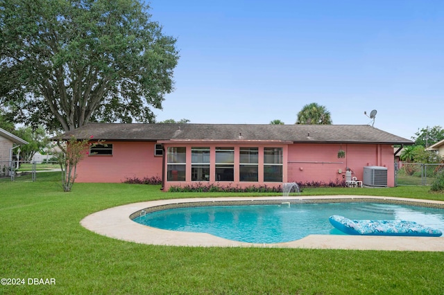 view of swimming pool featuring cooling unit, a yard, and pool water feature