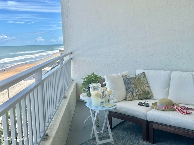 balcony featuring a water view and a beach view