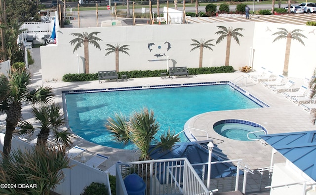 view of pool with a hot tub and a patio