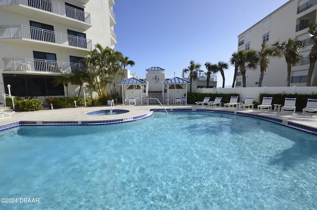 view of pool featuring a gazebo, a patio, and a hot tub