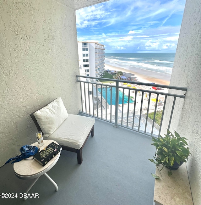 balcony featuring a water view and a view of the beach