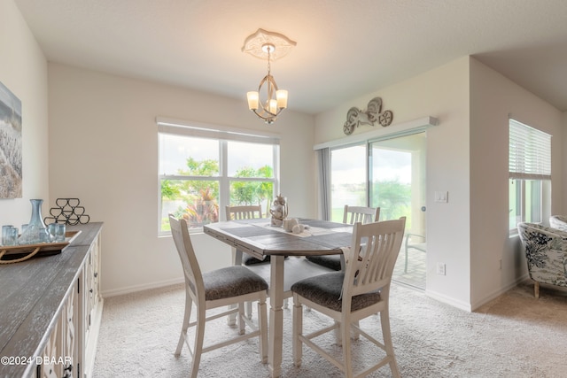 carpeted dining room featuring a notable chandelier