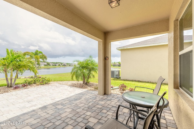 view of patio with central AC and a water view