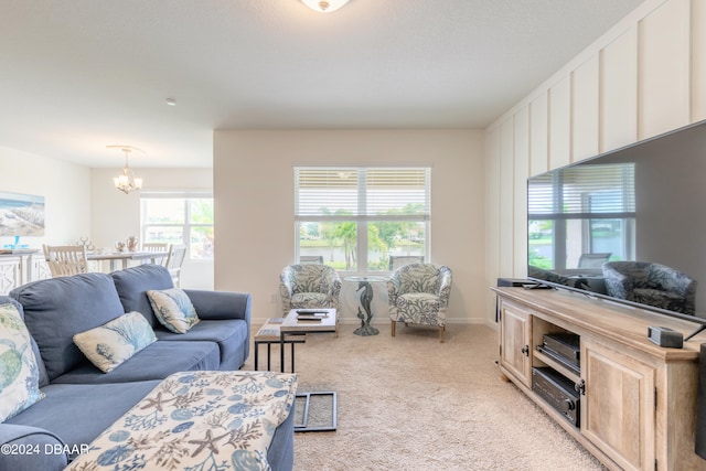 living room featuring light carpet and an inviting chandelier