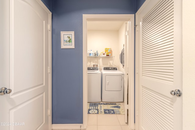 laundry area with washing machine and dryer and light tile patterned floors