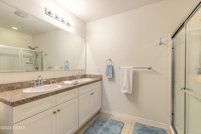 bathroom with walk in shower, vanity, and tile patterned floors