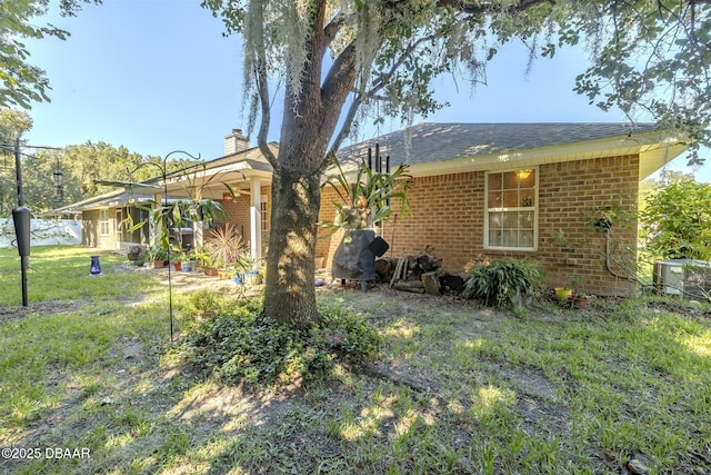 exterior space featuring central AC and a lawn