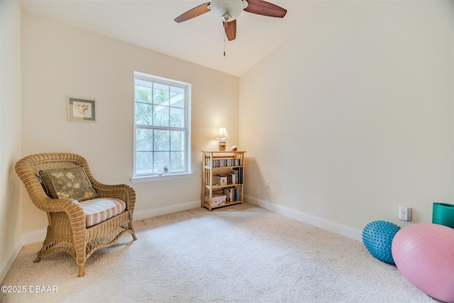 sitting room with vaulted ceiling, light colored carpet, and ceiling fan