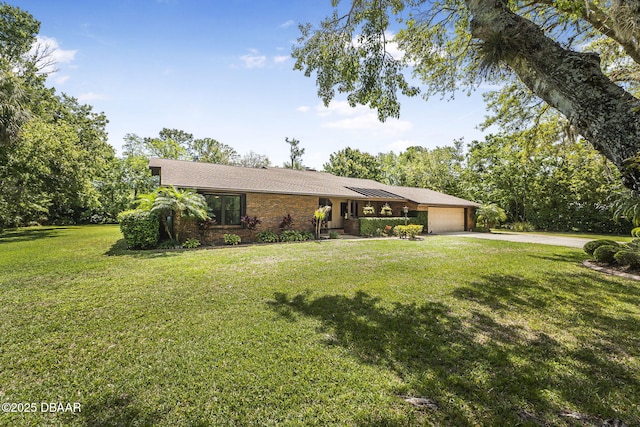 229 Riverbend Rd, Ormond Beach, FL 32174 - view of front of home featuring an attached garage, driveway, a front yard, brick siding, and roof with shingles