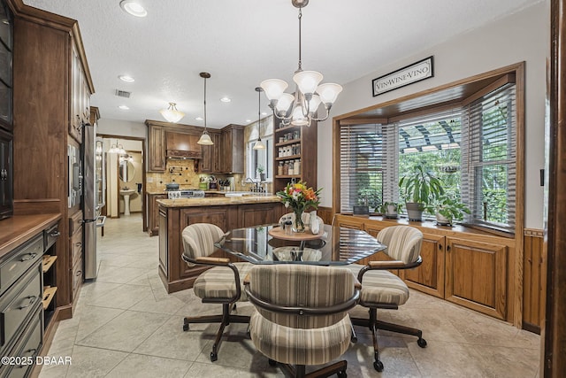 229 Riverbend Rd, Ormond Beach, FL 32174 - dining room with a chandelier, light tile patterned floors, recessed lighting, and a textured ceiling