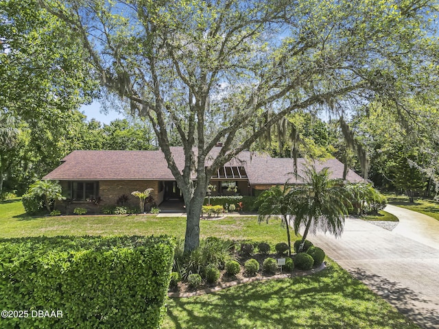 229 Riverbend Rd, Ormond Beach, FL 32174 - view of front of property with concrete driveway, a front yard, and a shingled roof