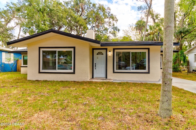 single story home with a front lawn