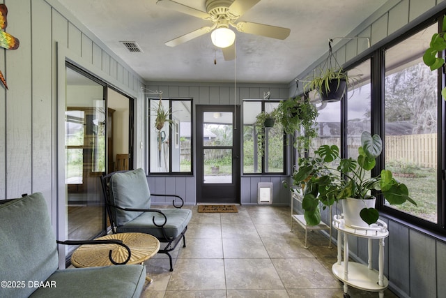 sunroom / solarium featuring visible vents, plenty of natural light, and a ceiling fan