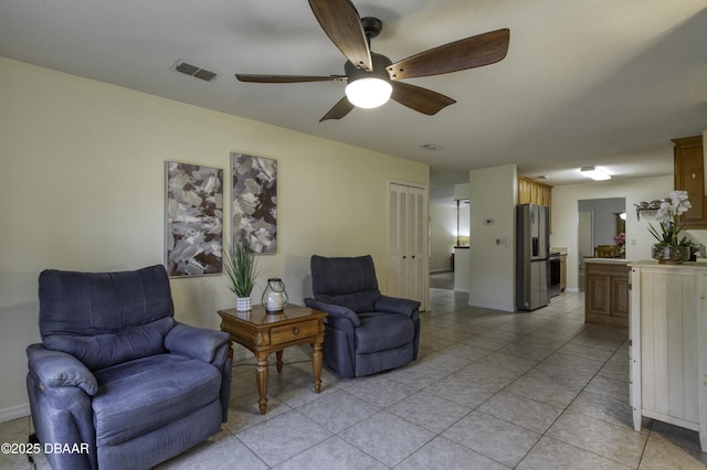 sitting room featuring light tile patterned flooring, baseboards, visible vents, and ceiling fan