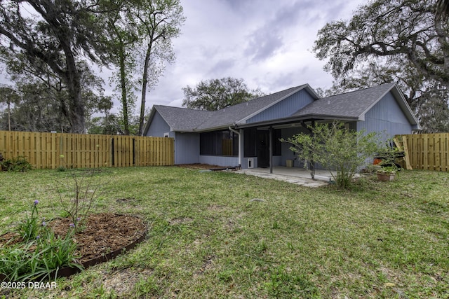 back of house featuring a patio area, a lawn, a fenced backyard, and roof with shingles