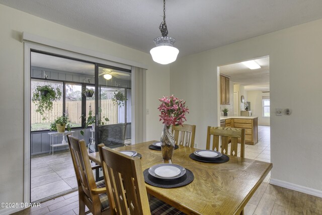 dining area featuring light wood-style flooring and baseboards