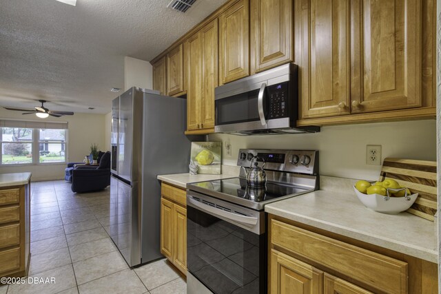 kitchen featuring brown cabinets, stainless steel appliances, and light countertops