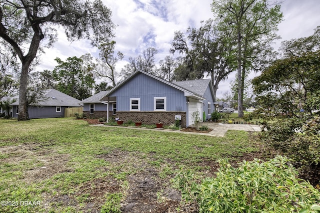 view of property exterior with brick siding, a lawn, driveway, and a garage