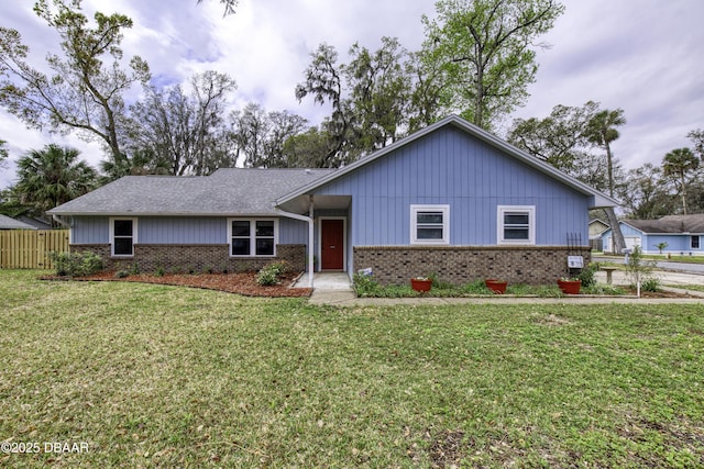 ranch-style house with brick siding, roof with shingles, a front lawn, and fence