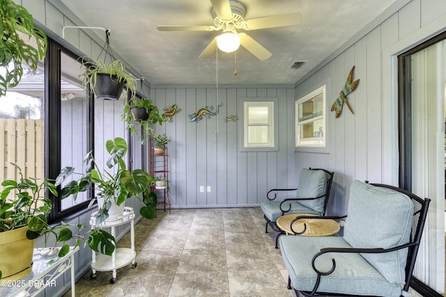 sunroom with a wealth of natural light, visible vents, and a ceiling fan