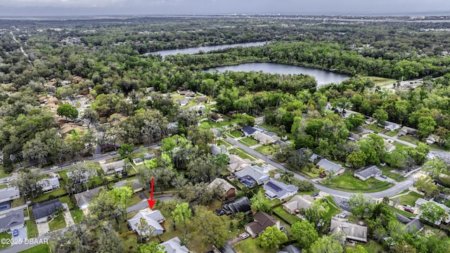 drone / aerial view featuring a forest view, a residential view, and a water view