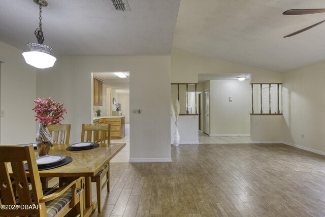 dining area featuring visible vents, lofted ceiling, ceiling fan, and light wood finished floors