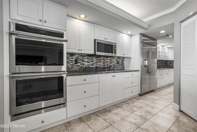 4621 S Atlantic Ave Ave Unit 7101, Ponce Inlet, FL 32127 - kitchen with stainless steel appliances, crown molding, decorative backsplash, white cabinets, and dark stone counters