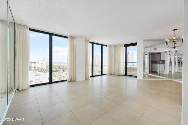 1 Oceans W Blvd Unit 8A2, Daytona Beach, FL 32118 - spare room featuring expansive windows, a chandelier, light tile patterned flooring, a view of city, and a textured ceiling