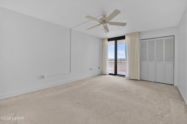 1 Oceans W Blvd Unit 8A2, Daytona Beach, FL 32118 - unfurnished bedroom featuring access to outside, carpet flooring, a ceiling fan, baseboards, and a textured ceiling
