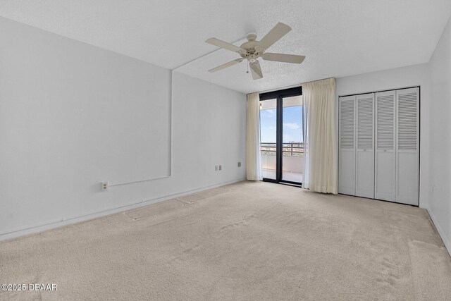 1 Oceans W Blvd Unit 8A2, Daytona Beach, FL 32118 - unfurnished bedroom featuring access to outside, carpet flooring, a ceiling fan, baseboards, and a textured ceiling