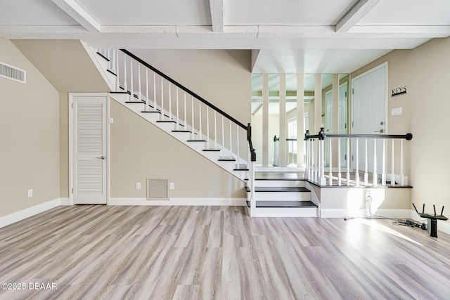 entrance foyer featuring beamed ceiling and light hardwood / wood-style flooring