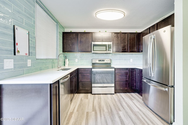 kitchen featuring light hardwood / wood-style floors, stainless steel appliances, backsplash, dark brown cabinets, and sink