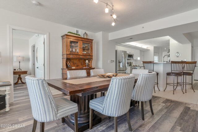 dining space featuring ceiling fan, wood-type flooring, a textured ceiling, and floor to ceiling windows