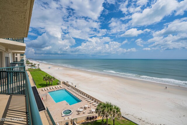 balcony featuring a view of the beach and a water view